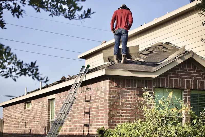 Professional roofer working on a residential roof in Gilbertsville